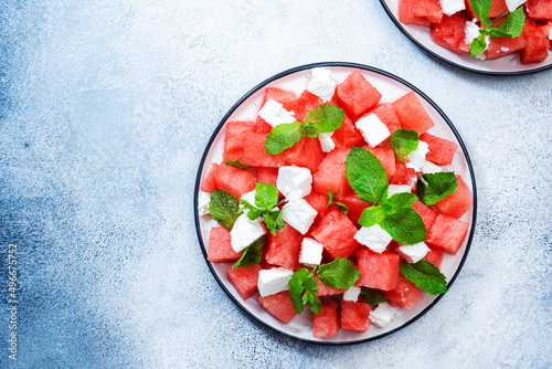 Refreshing summer juicy Watermelon salad with feta cheese and fresh mint, gray table background, top view, copy space