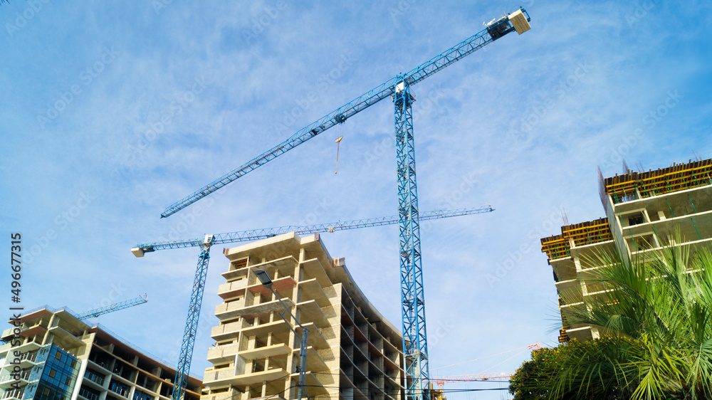 Three blue tower cranes are building residential ladies Three blue tower cranes are building residential ladies