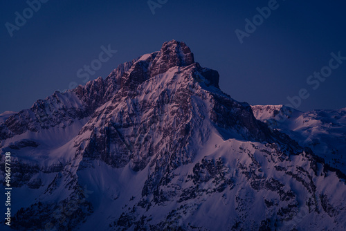 Die Morgendämmerung beleuchtet den Mürtschenstock in den winterlich verschneiten Glarner Alpen in der Schweiz