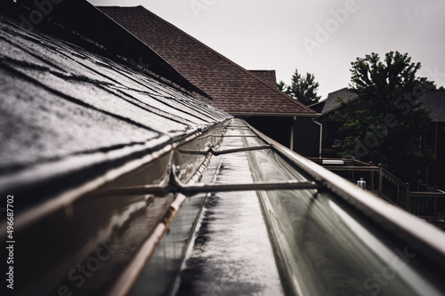 Obraz na płótnie Selective focus on a section of residential guttering with hanger conveying water during a storm