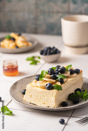 Homemade cottage cheese bake cake casserole with berries and banana on white background