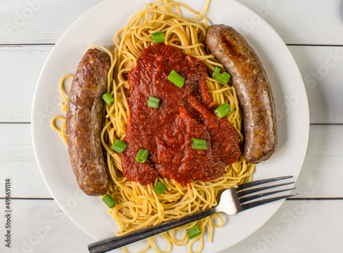 spaghetti top with sauce and green onions photo