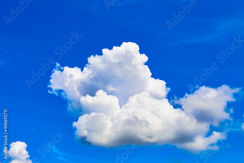 Fototapeta Naklejka Na Ścianę i Meble -  One isolated white cloud in a blue sky. Heaven background. Wallpaper. Beautiful cloudscape. Cumulus clouds. Weather forecast. Outdoor natural landscape. Banner. Dreams. Summer season