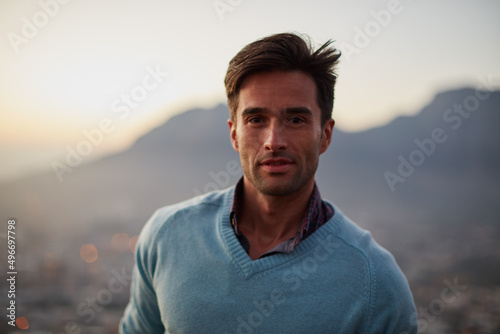 Breathing in the fresh air. Portrait of a happy young man posing in front of a city view.