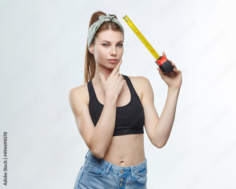beautiful blonde girl holds a measuring tape in her hands. measurement concept about penis size beautiful blonde girl holds a measuring tape in her hands. measurement concept about penis size