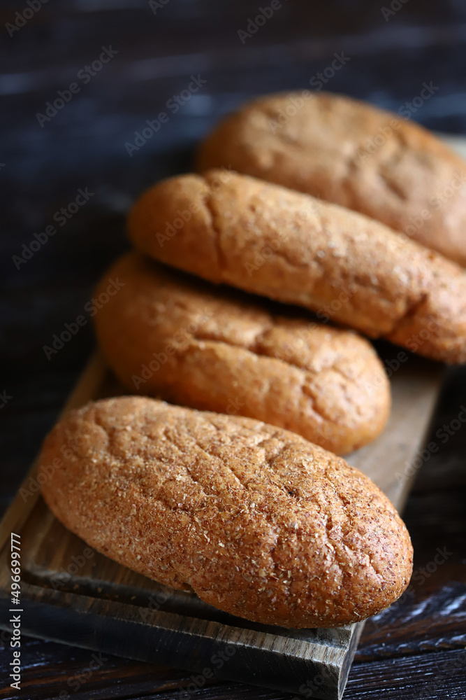 Fresh buns with bran on a wooden surface. Wholemeal bread. Fresh buns with bran on a wooden surface. Wholemeal bread.