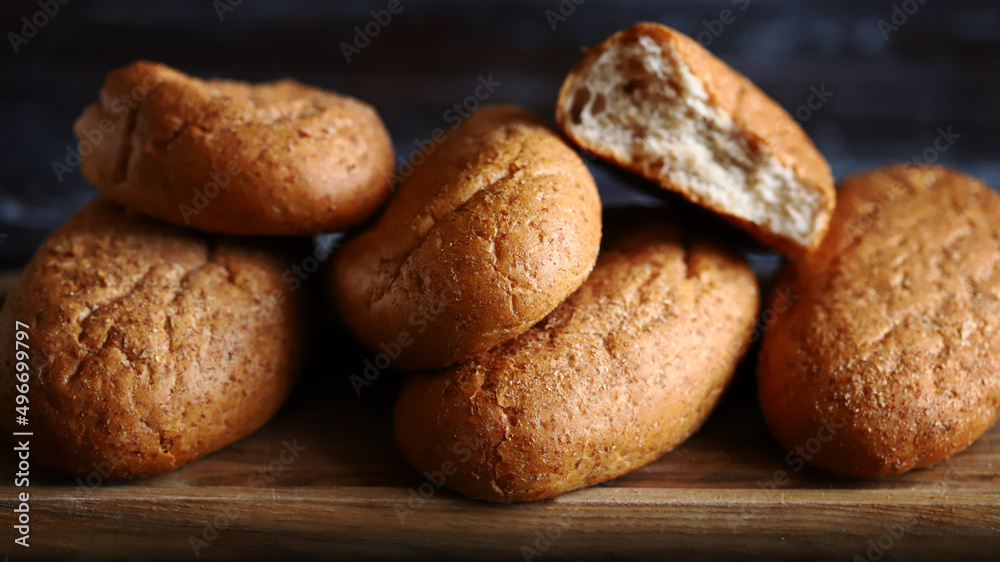 Fresh buns with bran on a wooden surface. Wholemeal bread.