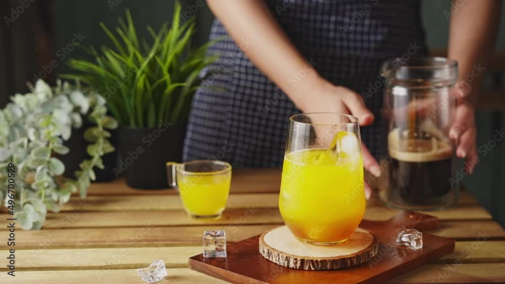 Iced black coffee With orange Juice. Cold coffee with tonic. The barista mixes ice cubes, tonic and cold coffee. Iced black coffee With orange Juice. Cold coffee with tonic. The barista mixes ice cubes, tonic and cold coffee.