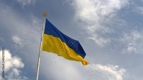 Ukrainian national official flag on flagpole waving in the wind on picturesque sky background photo