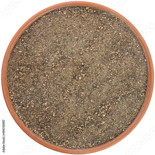 Coarsely ground black pepper in a brown ceramic bowl isolated on white background. Isolated close-up photo of food close up from above on white background.