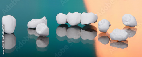 High aesthetic zirconia dentures and crowns on colorful background. Set of single dentures and dental crowns. photo