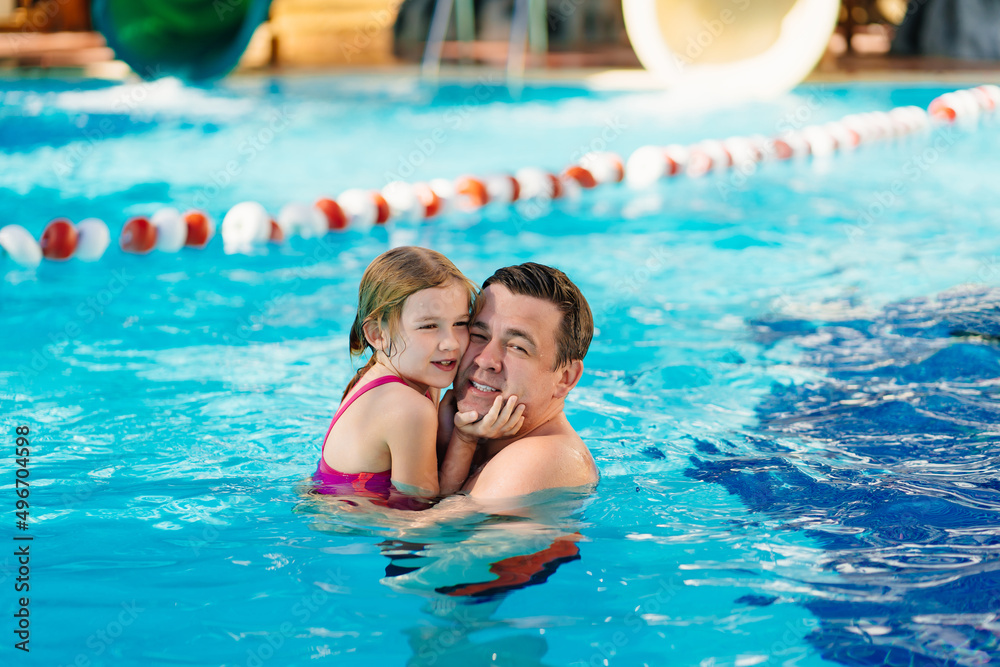 dad and daughter cuddle and swim in the pool. swimming training. 