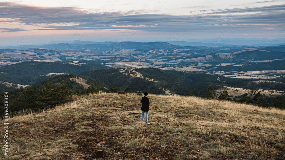 Woman on a viewpoint is watching a beautiful landscape in front of her Woman on a viewpoint is watching a beautiful landscape in front of her