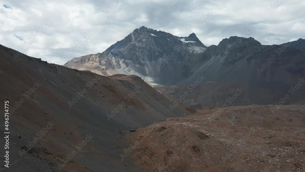 Aerial pan right of Andean mountain range, Meson Alto Hill and Glacier in background on a cloudy day, Cajon del Maipo, Chile Aerial pan right of Andean mountain range, Meson Alto Hill and Glacier in background on a cloudy day, Cajon del Maipo, Chile