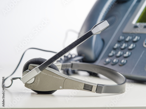 Landline phone and headphones. Isolated on white background. Close-up. Office, communication center, customer service. Minimalism. There are no people in the photo. Banner.