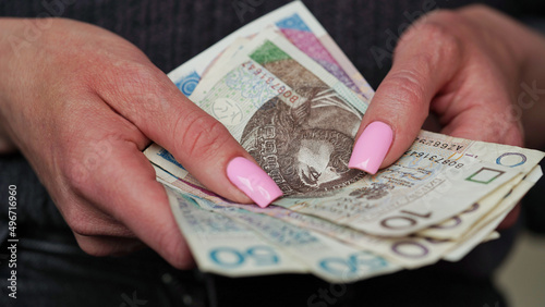 Close-up of female hands holding zloty banknotes, Polish currency. The concept of currency exchange in another country. Tourism and travel. Selective focus.