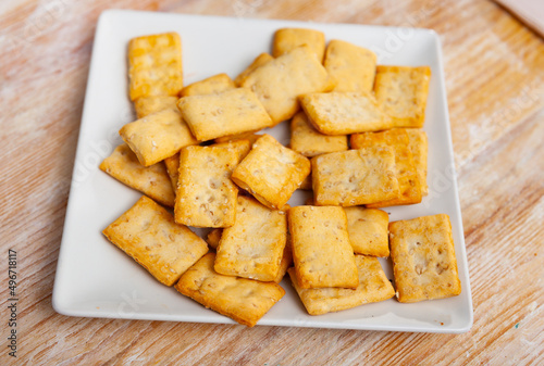 Delicious crackers in a plate on a wooden table. Close-up image