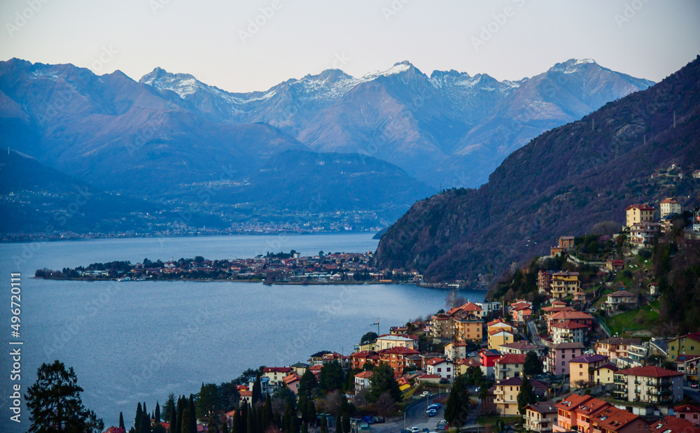 Aerial view to the town located on the shore of Lake Como, Italy. Amazing silhouette of Alp Mountains around.