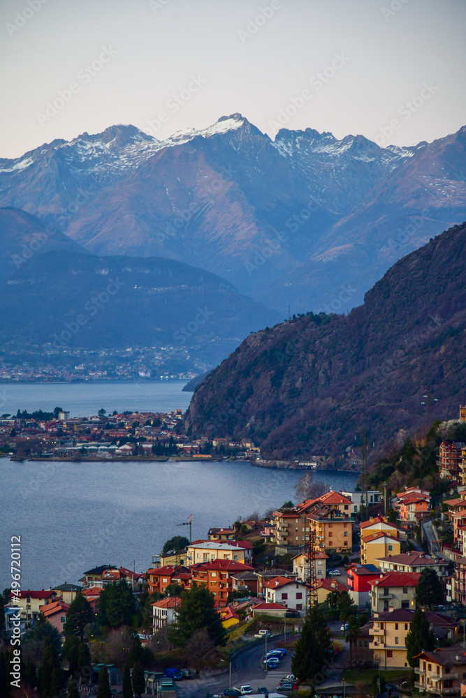 Aerial view to the town located on the shore of Lake Como, Italy. Amazing silhouette of Alp Mountains around.