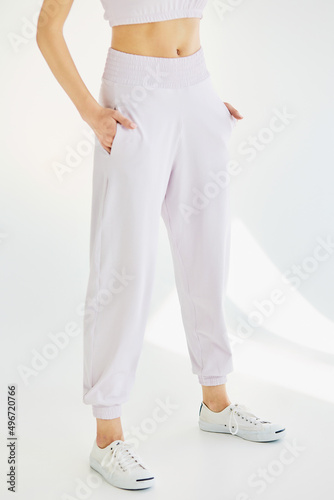 A young girl in pink sweatpants on a white background