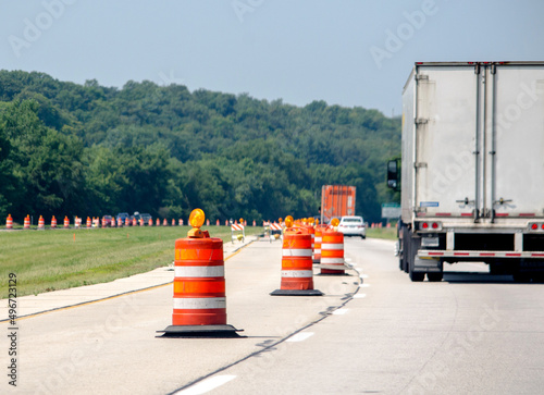 Highway construction season with traffic going past orange traffic cones
