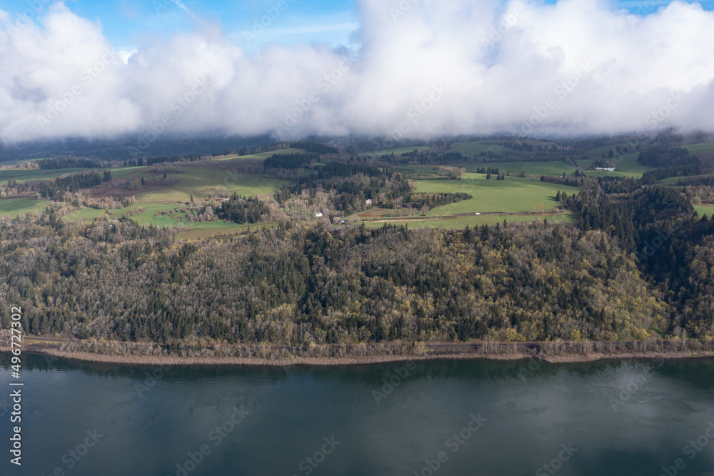 Low clouds drift over the Columbia River Gorge between Oregon and Washington. This scenic, narrow canyon, with the Columbia River flowing through it, is over 80 miles long.