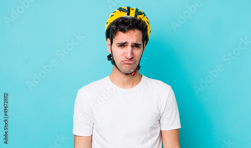 handsome hispanic man feeling sad and whiney with an unhappy look and crying. bike concept photo