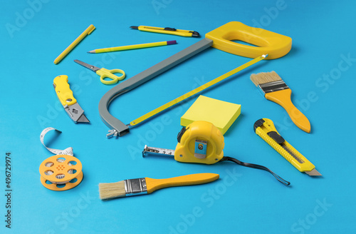 A large set of yellow hand tools on a blue background.