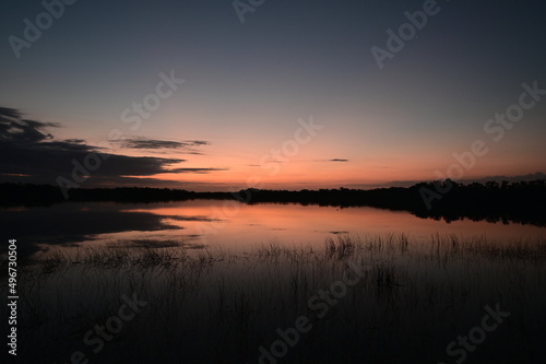 Colorful sunrise reflected in the calm water of Nine Mile Pond in Everglades National Park, Florida.