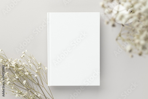 White book blank cover mockup on a beige background with dry flower, flat lay, mockup