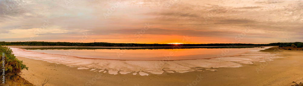 Sunrise and its kaleidoscope of colours over a dry salt lake in the Australian outback.