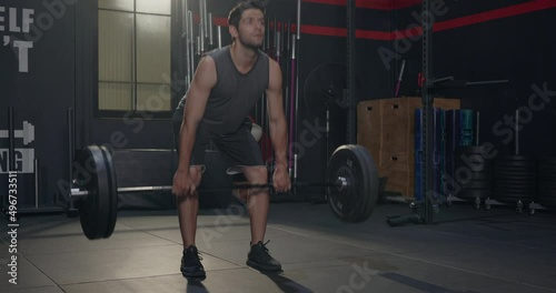 Muscular young Caucasian man exercises working out with lifting weights heavy barbell, Male bodybuilder having workout in gym and fitness club during alone training