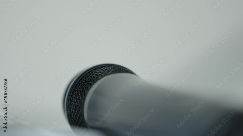 Slow zoom in on a microphone laying on its side, blurred background ...