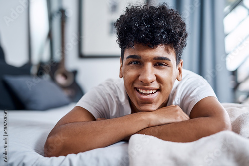 No better hangout spot than home. Shot of a young man relaxing on his bed at home.