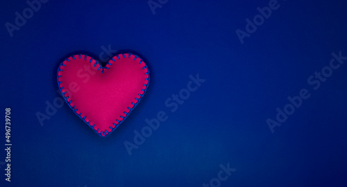 Handmade felt heart over blue background