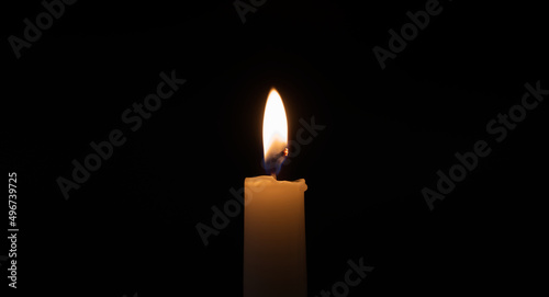 Burning candle in the darkness