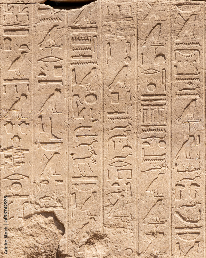 Ancient Egyptian hieroglyphs on the stone walls of the Karnak Temple in Luxor, Egypt