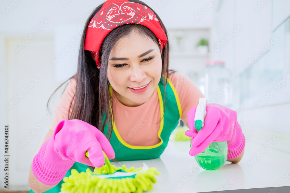 Woman cleaning table with a duster and spray Woman cleaning table with a duster and spray