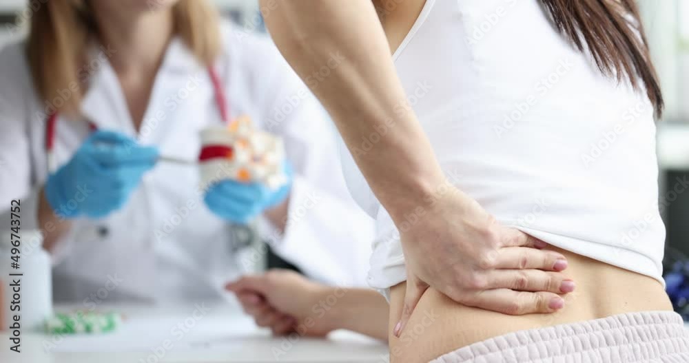 Doctor consults patient suffering from back pain closeup Doctor consults patient suffering from back pain closeup