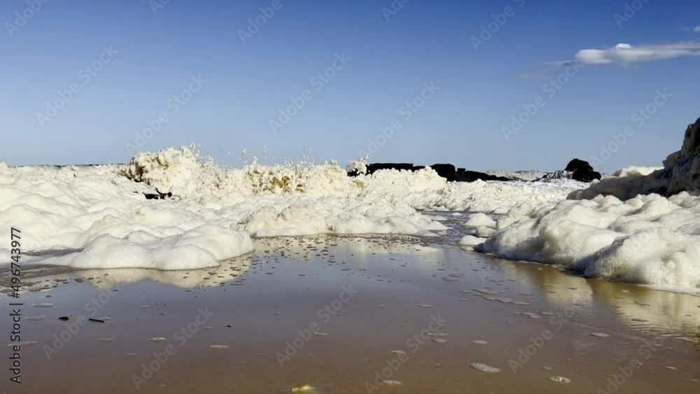 Slow motion splash effects created when surf waves pass through a huge amount of seafoam near the shoreline. Slow motion splash effects created when surf waves pass through a huge amount of seafoam near the shoreline.
