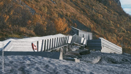 Tungenesset rest area on Sneja. A  wooden footpath leads out over the rocks to the coast. Autumn forest on the mountain slopes.Slow-motion, pan right. photo