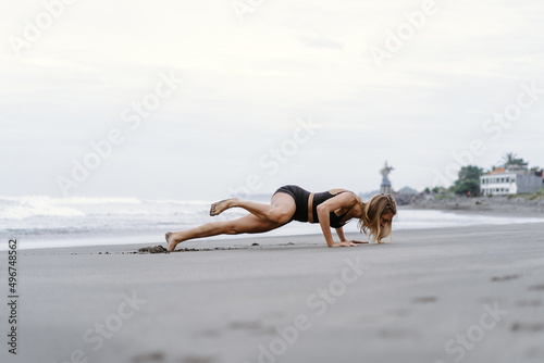 Sporty woman doing mountain climber exercise - run in plank to burn fat. Sunset beach  blue sky background. Healthy lifestyle at tropical island yoga retreat  outdoor activity  family summer vacation.