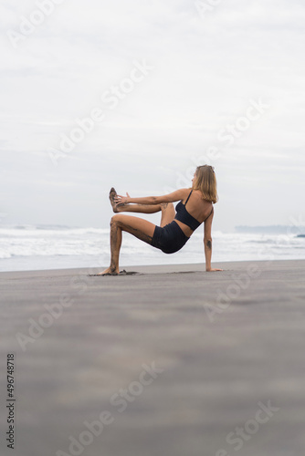 Sporty woman doing mountain climber exercise - run in plank to burn fat. Sunset beach, blue sky background. Healthy lifestyle at tropical island yoga retreat, outdoor activity, family summer vacation. © Yuliya Kirayonak