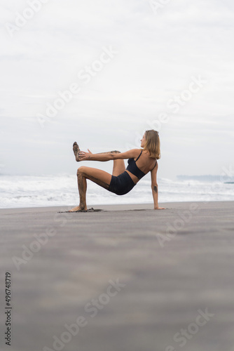 Sporty woman doing mountain climber exercise - run in plank to burn fat. Sunset beach, blue sky background. Healthy lifestyle at tropical island yoga retreat, outdoor activity, family summer vacation. © Yuliya Kirayonak