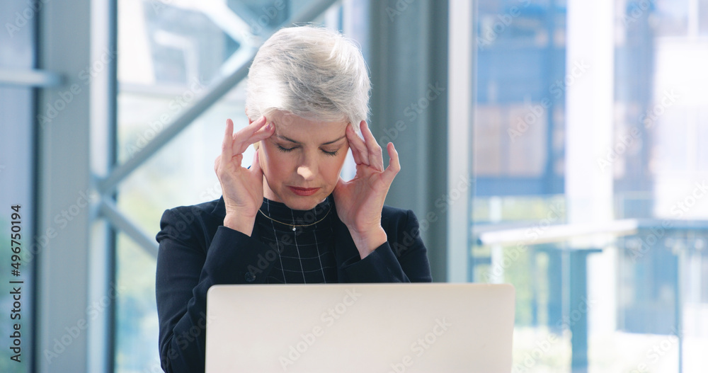 These deadlines are giving me a headache. Shot of a mature businesswoman looking stressed out while working in an office. These deadlines are giving me a headache. Shot of a mature businesswoman looking stressed out while working in an office.
