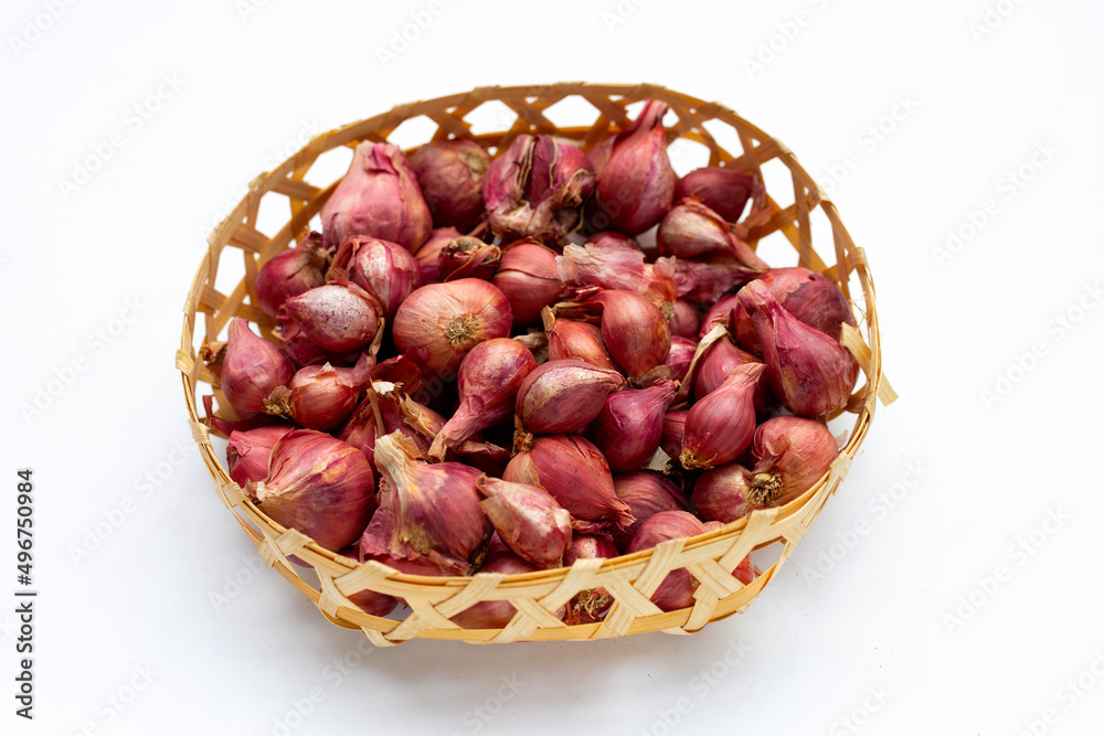 Obraz premium Shallots onion isolated in bamboo basket on white background.
