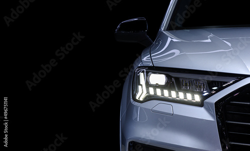 Close-up front headlight with LED xenon light of grey modern EV Car on black color background and copy space