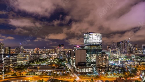 Melbourne Australia Victoria night timelapse rooftop view of big sky scrapers roads and Melbourne star looking at the west cars going past. photo