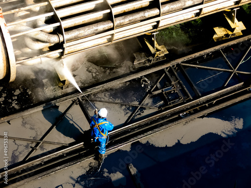 People are working on high-pressure water machines to wash away the impurities of petrochemical equipment.