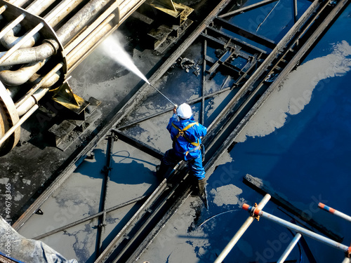 People are working on high-pressure water machines to wash away the impurities of petrochemical equipment.